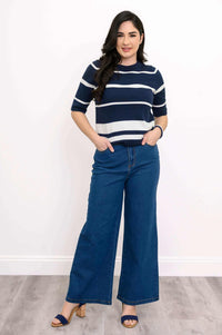 Woman modeling navy and white striped cotton sweater with hands in pockets