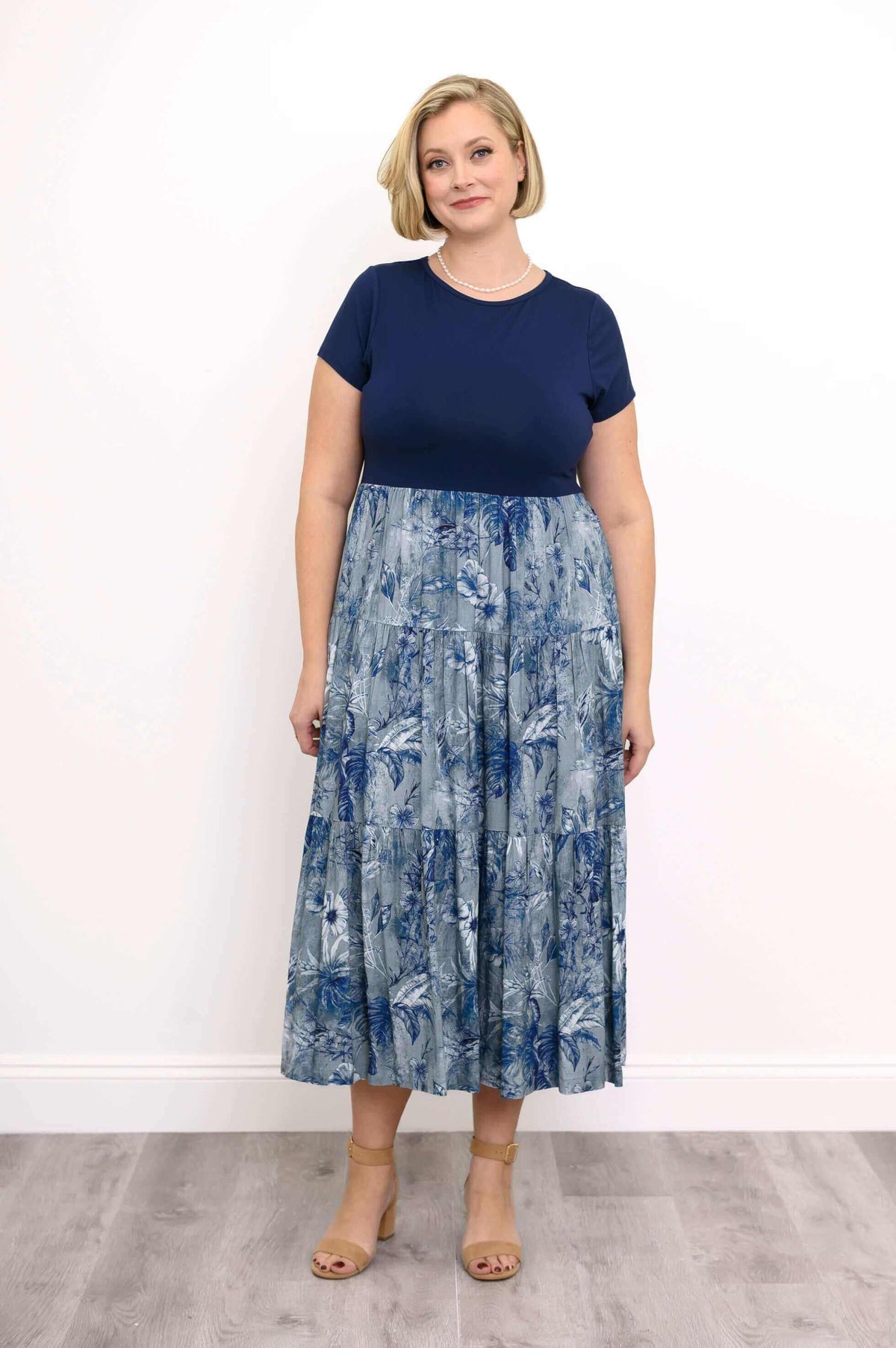Woman wearing a navy blue and floral patterned midi dress with short sleeves