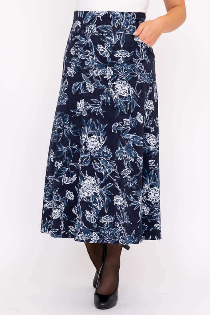 Close-up of model wearing navy blue floral A-line midi skirt with pockets