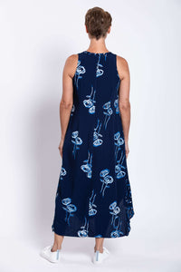 Back view of a woman in a navy blue sleeveless midi dress with white and blue floral design