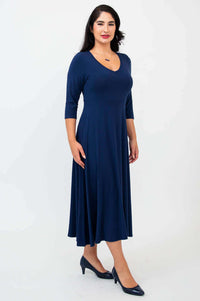 Woman in a navy blue midi dress, side profile with three-quarter sleeves