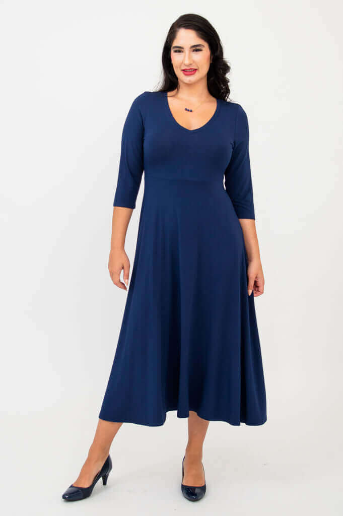 Woman wearing a navy blue midi dress with three-quarter sleeves, front view
