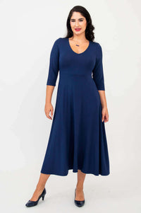 Woman wearing a navy blue midi dress with three-quarter sleeves, front view