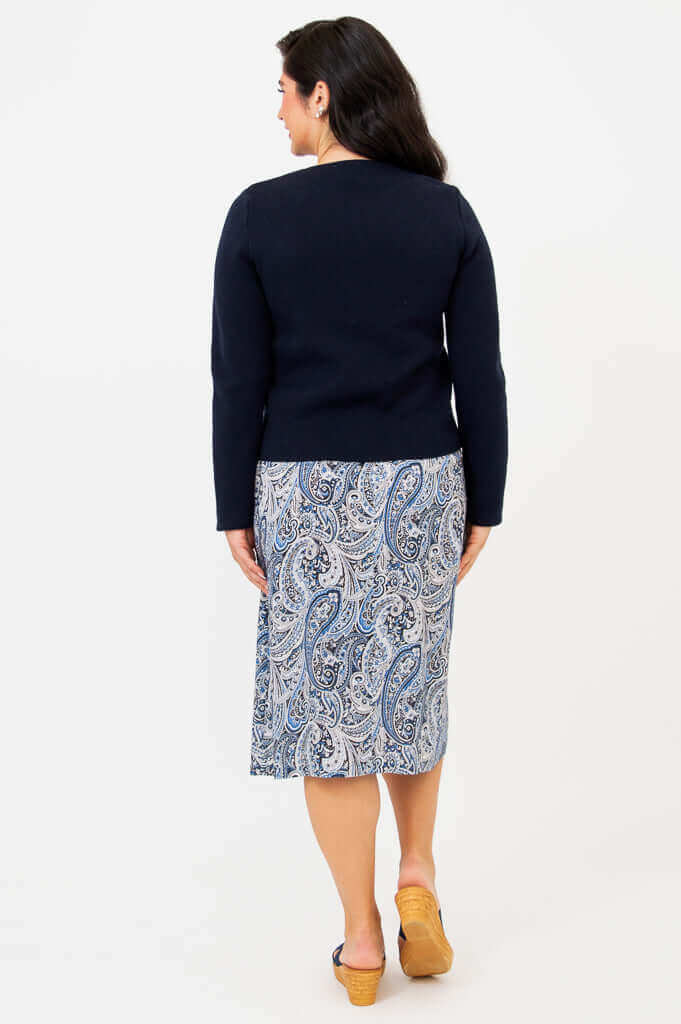 Back view of navy cardigan and blue paisley skirt on model