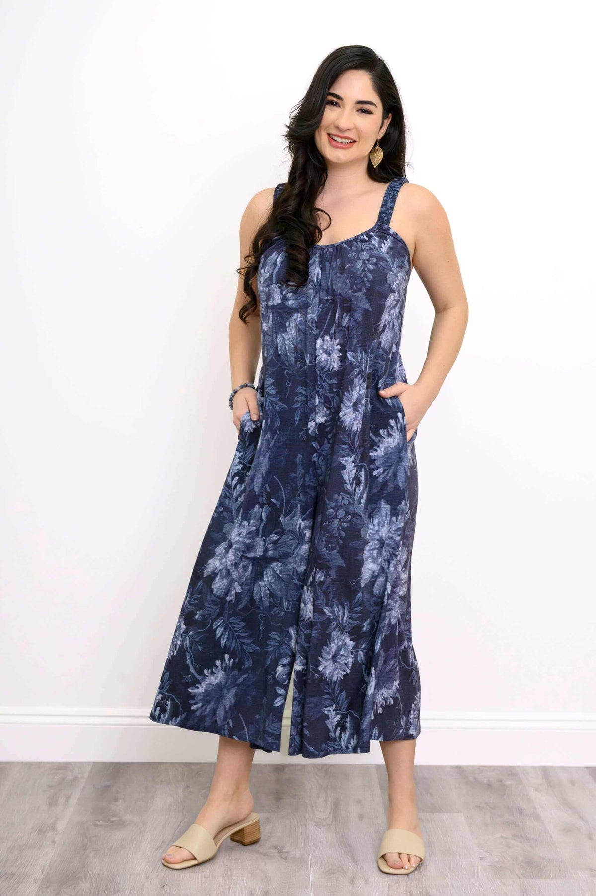 Woman wearing navy floral jumpsuit with sweetheart neckline and pockets