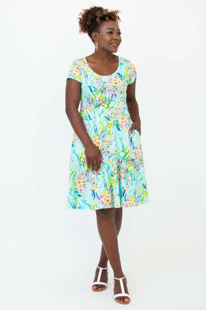 Woman wearing Nicola blue floral cap sleeve A-line dress with pockets, front view