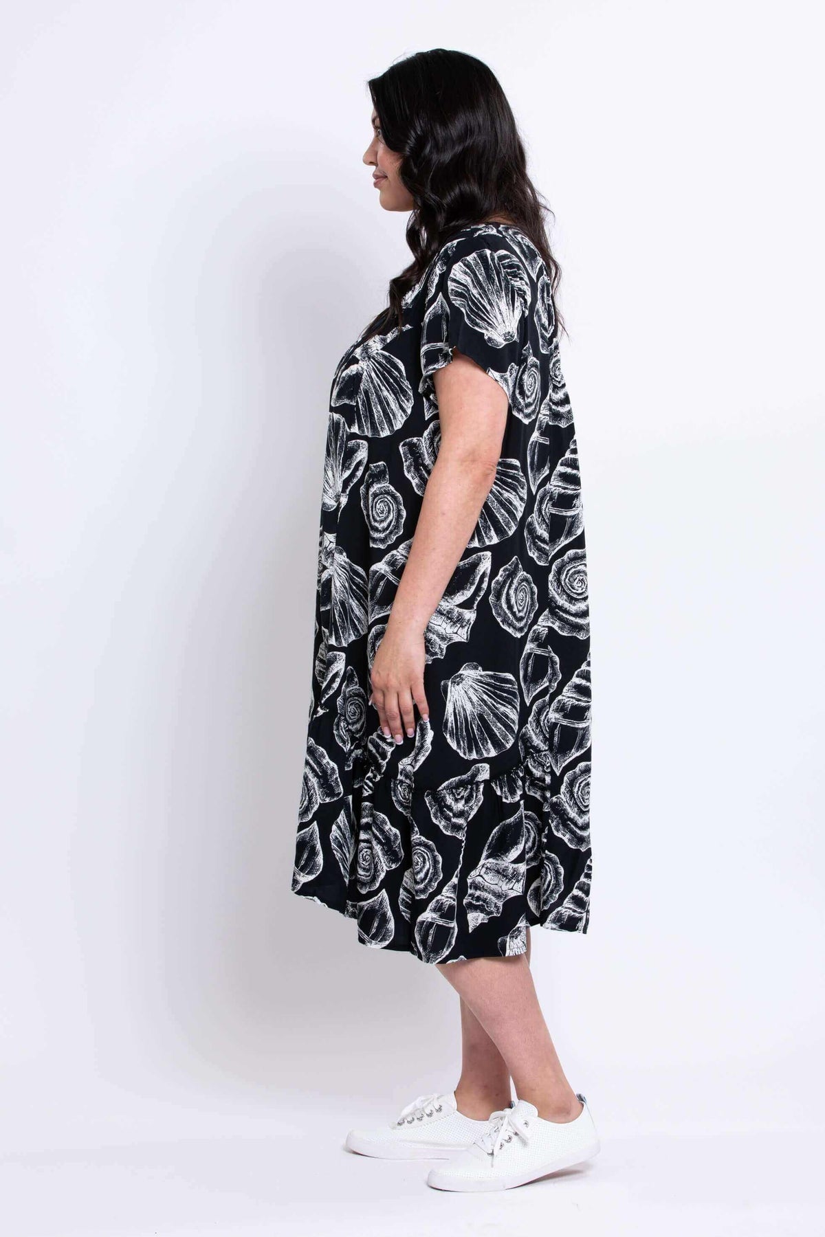 Side view of model in the Noosa Dress with relaxed fit and ruffled hem