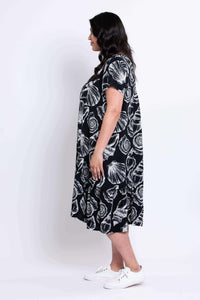Side view of model in the Noosa Dress with relaxed fit and ruffled hem