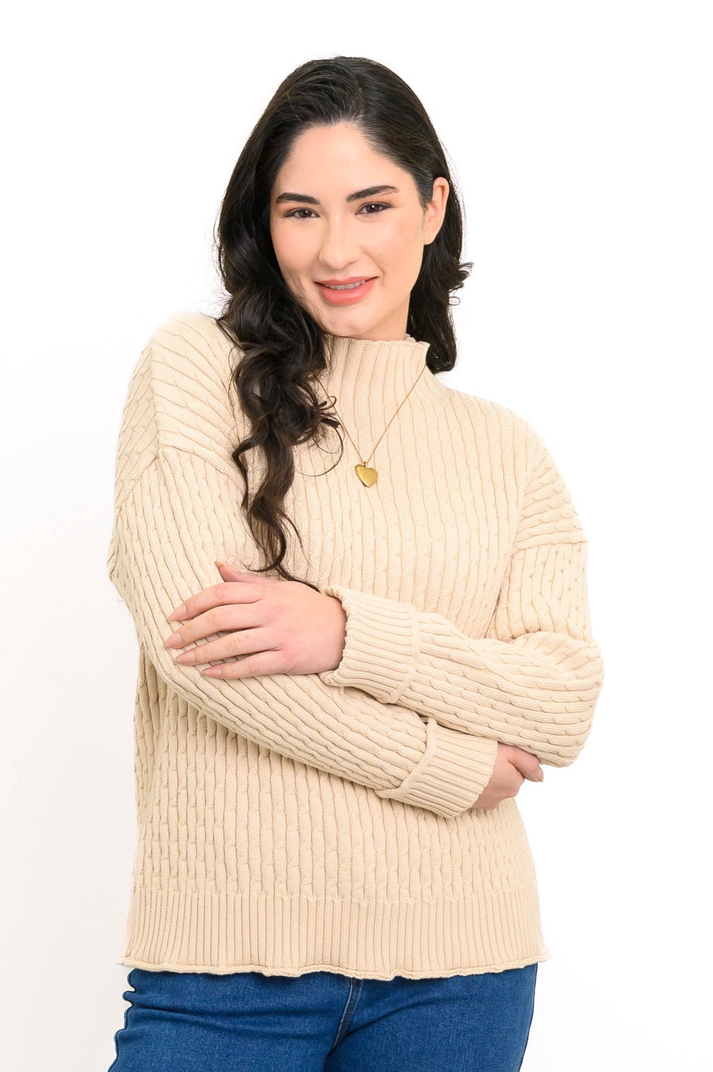Cream mock neck pullover shirt with structured sleeves and a rolled hem finish, styled with blue denim.