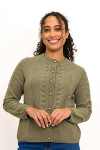 Close up front view of a woman wearing an olive green cable knit cashmere cardigan sweater with pearl buttons.