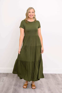 Woman in olive green tiered maxi dress with short sleeves and tan sandals