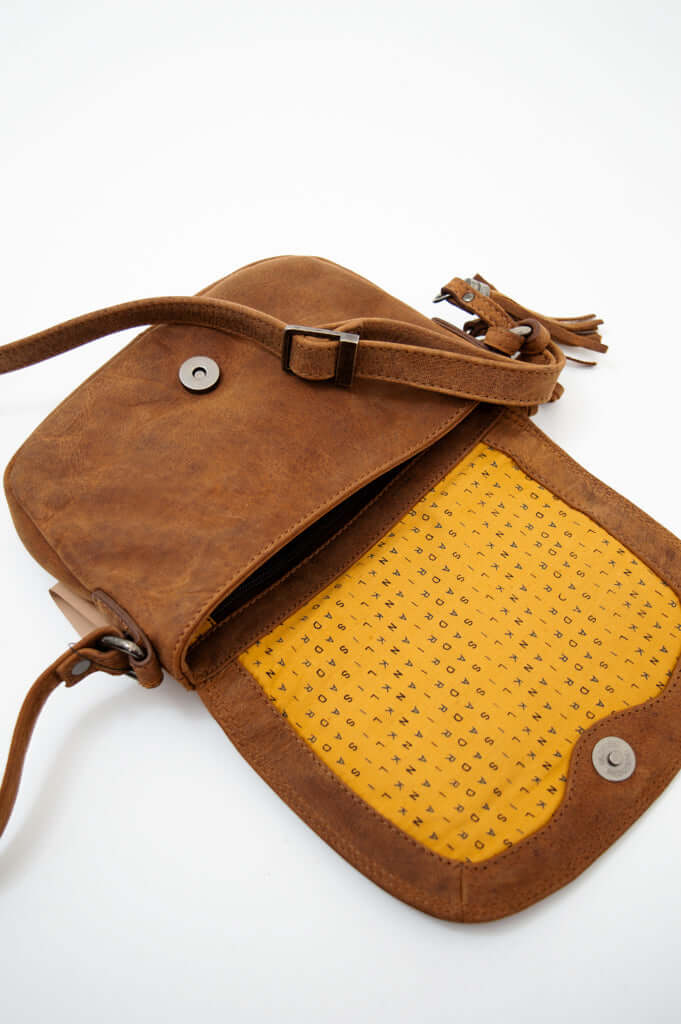 Open brown leather crossbody bag showing yellow patterned interior