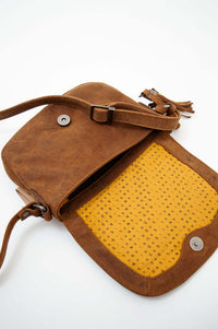 Open brown leather crossbody bag showing yellow patterned interior
