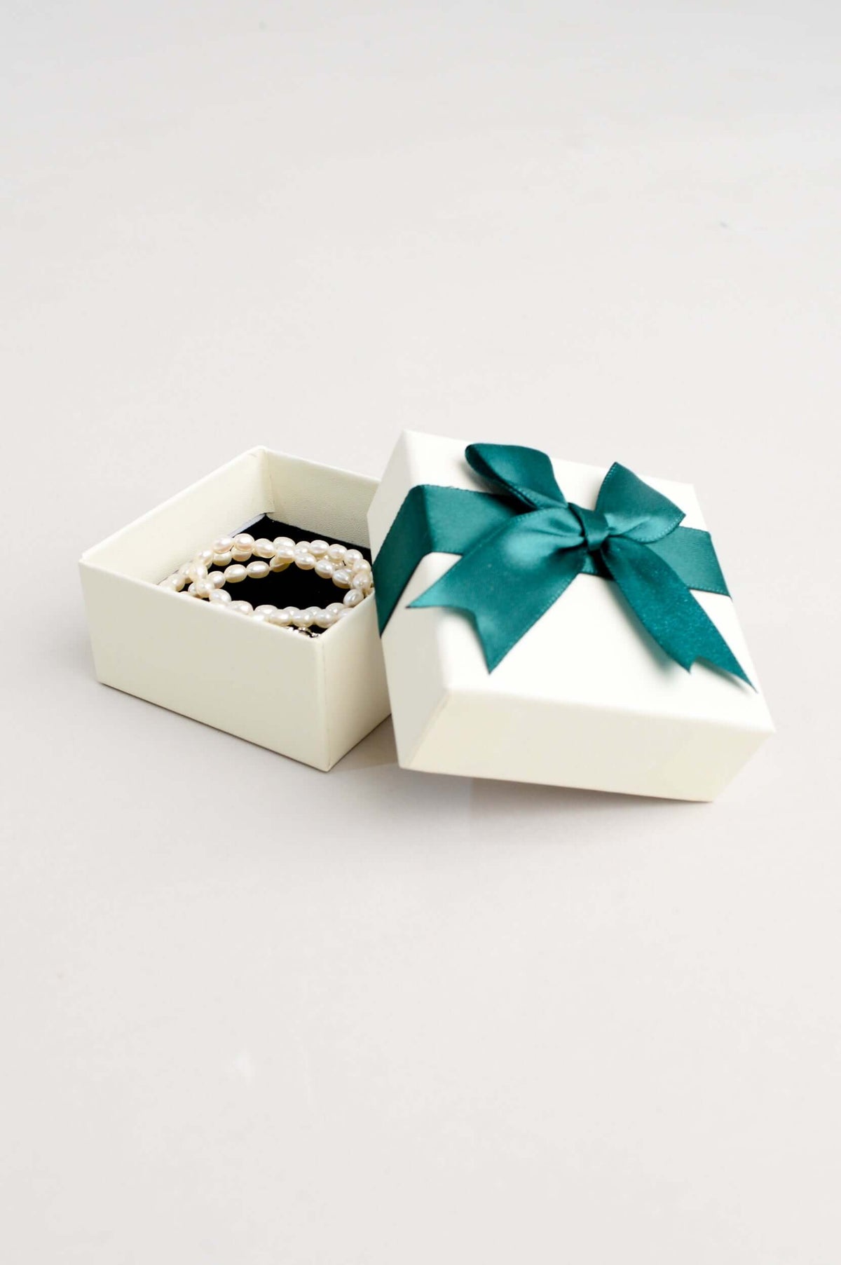 Classic pearl necklace placed inside a cream gift box with an open lid