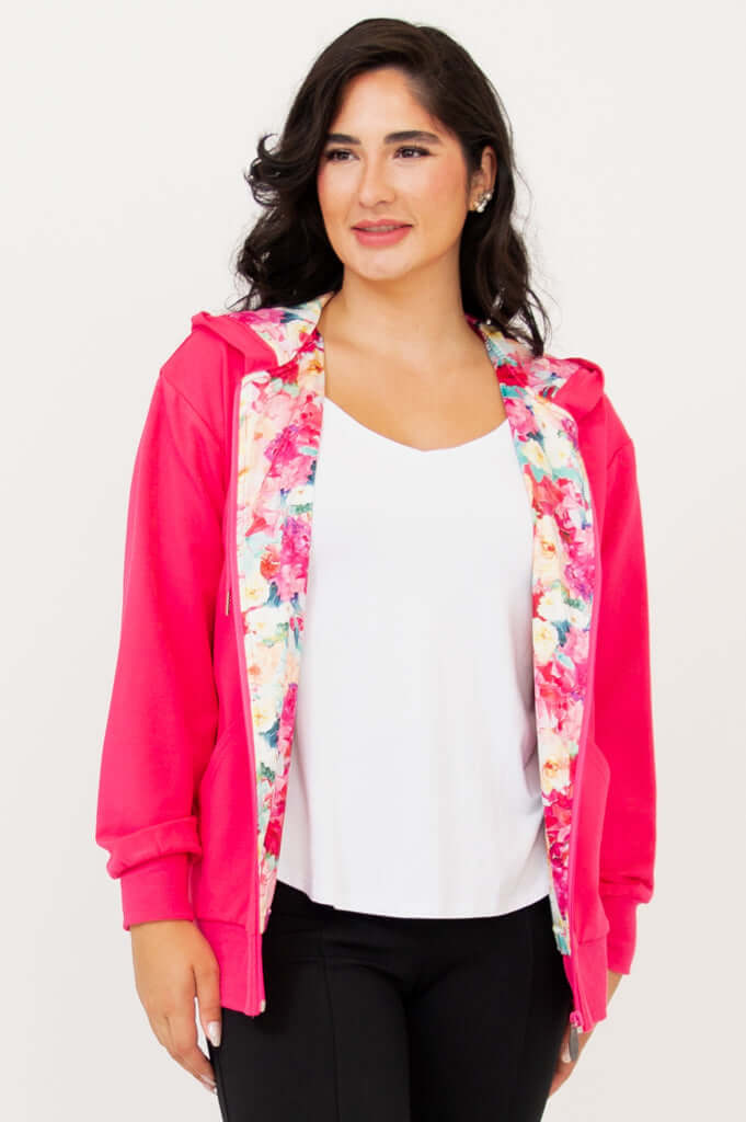 Woman in open fuchsia hoody showing floral-printed lining, white shirt underneath