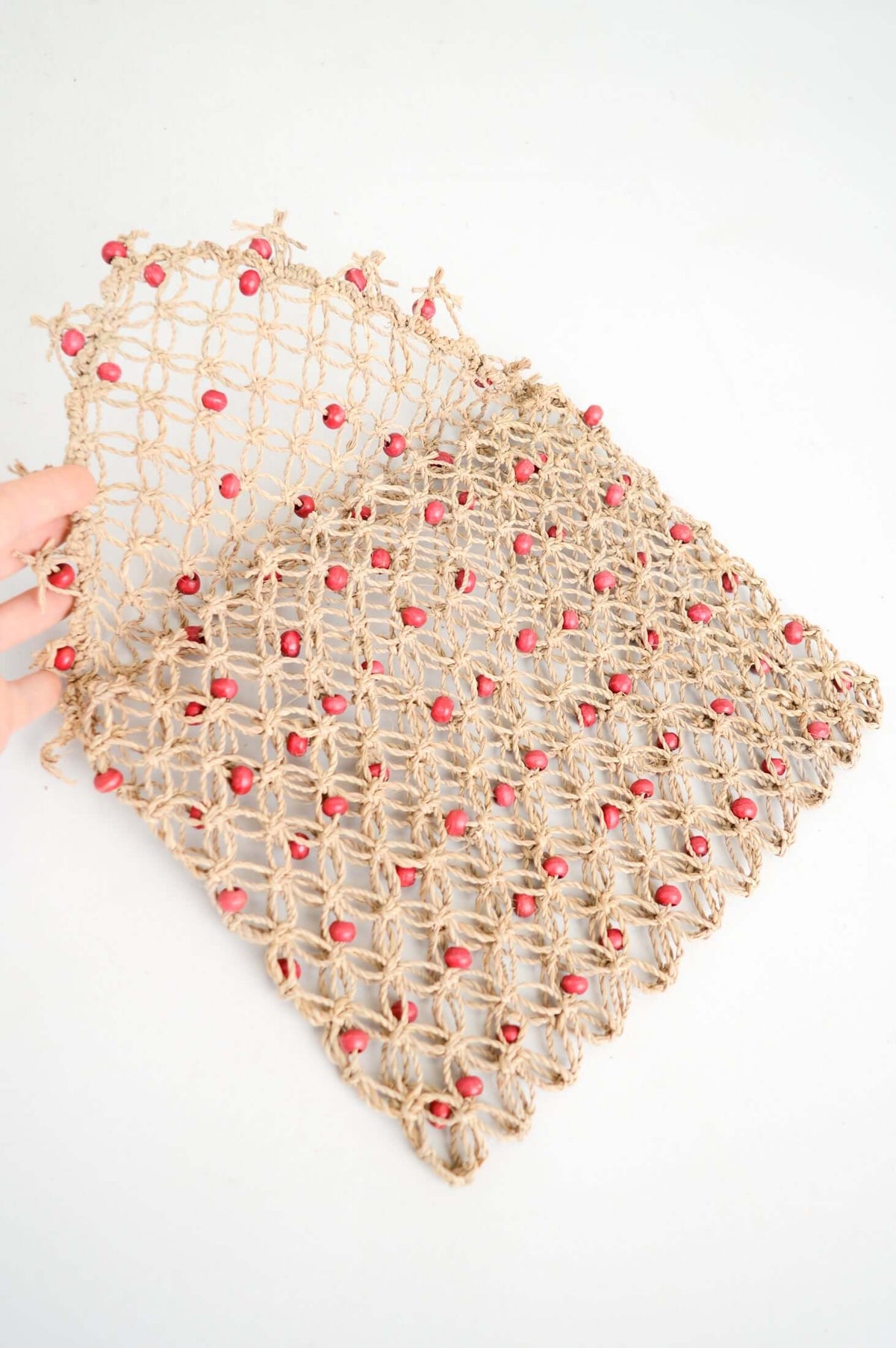 Open handwoven rattan purse with coral beads showing inner space