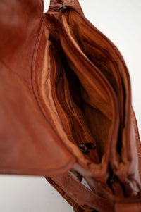 Open messenger bag showing multiple compartments and zipped sections