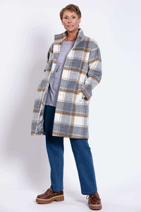 Woman standing with open plaid wool coat, showing lined interior