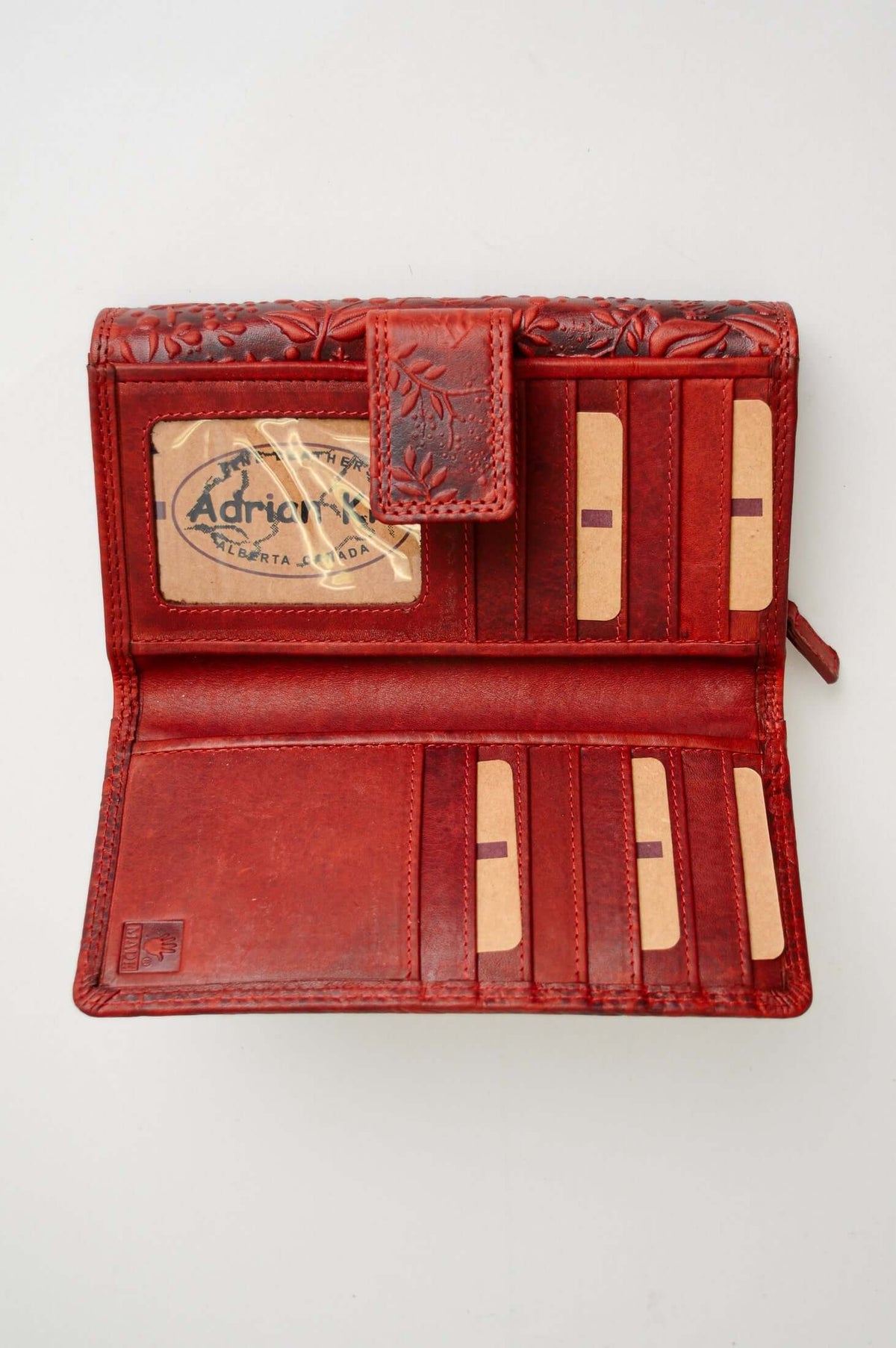 Open red leather wallet showing card slots and ID window