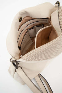 Open view of ivory handbag showing zipper and organized interior pockets