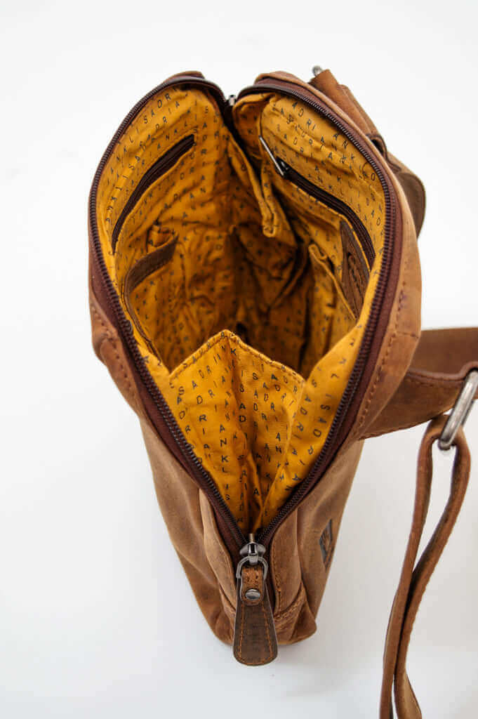 Top-down view of the brown leather crossbody bag with organized yellow interior and pockets