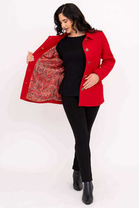 Woman showing the paisley patterned silky lining inside the red coat