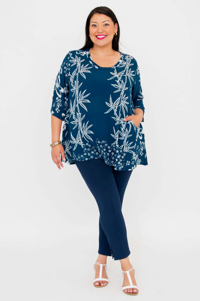 Woman wearing indigo bamboo blouse with hand in pocket, smiling