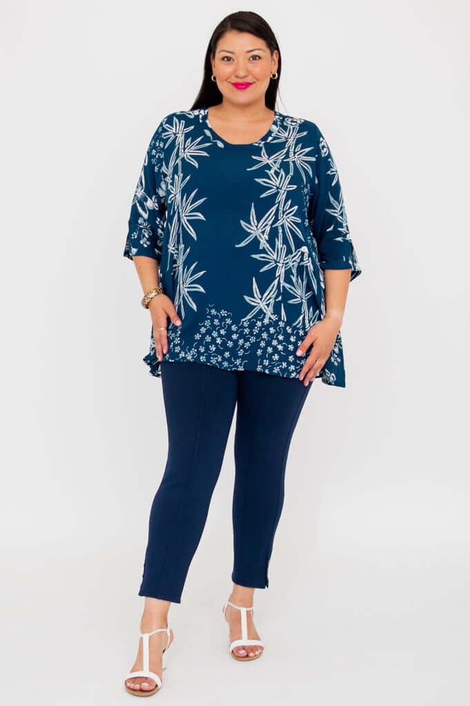 Full body view of woman in indigo bamboo print blouse and navy pants