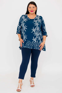 Full body view of woman in indigo bamboo print blouse and navy pants