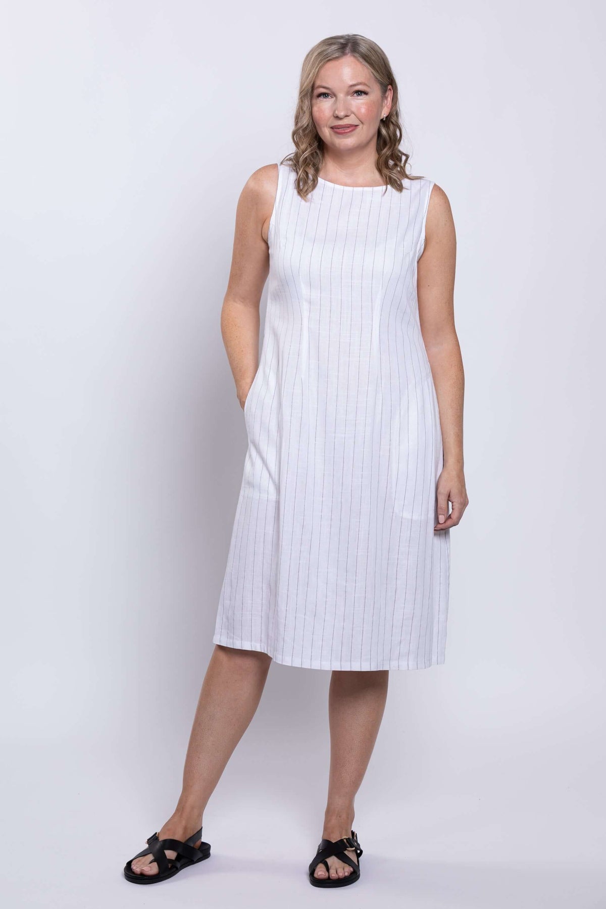 Woman modeling a white sleeveless striped midi dress with a relaxed A-line fit
