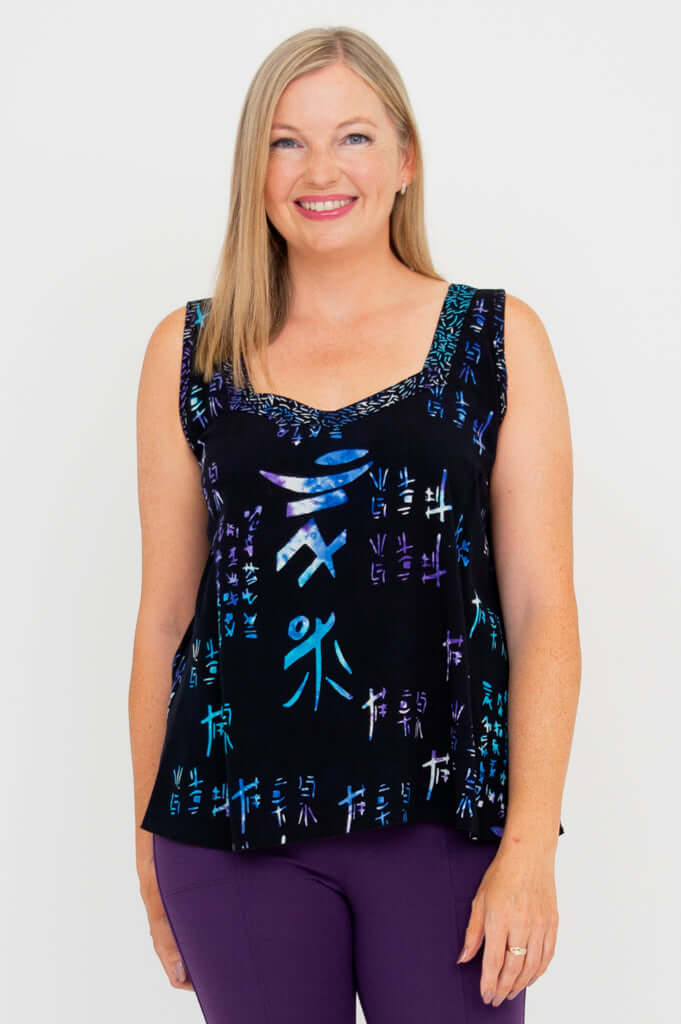 Woman wearing a black sweetheart neckline tank top with vibrant batik pattern