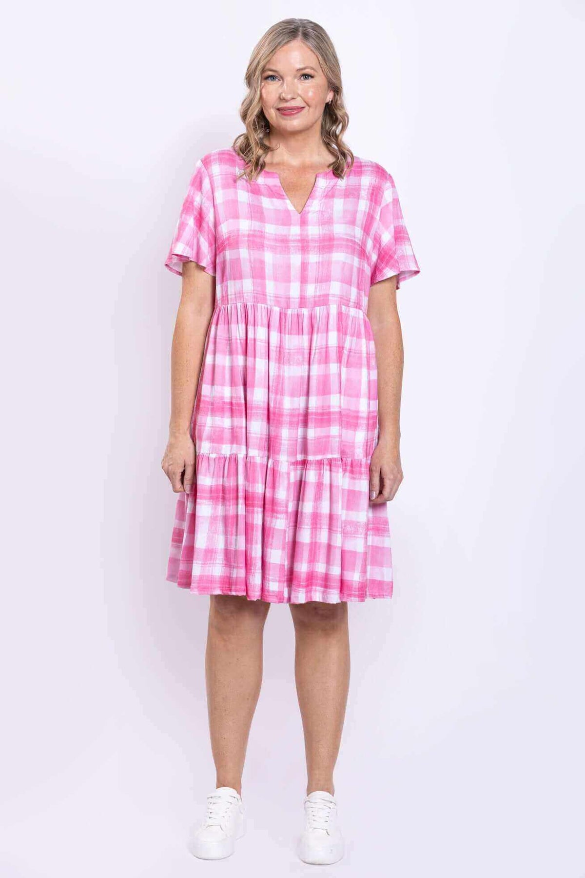Front pose of woman in pink check dress with tiered skirt and short sleeves