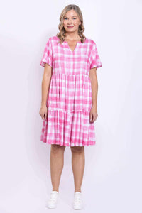 Front pose of woman in pink check dress with tiered skirt and short sleeves