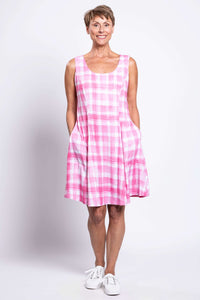 Woman with hands in pockets wearing a pink plaid sleeveless A-line dress