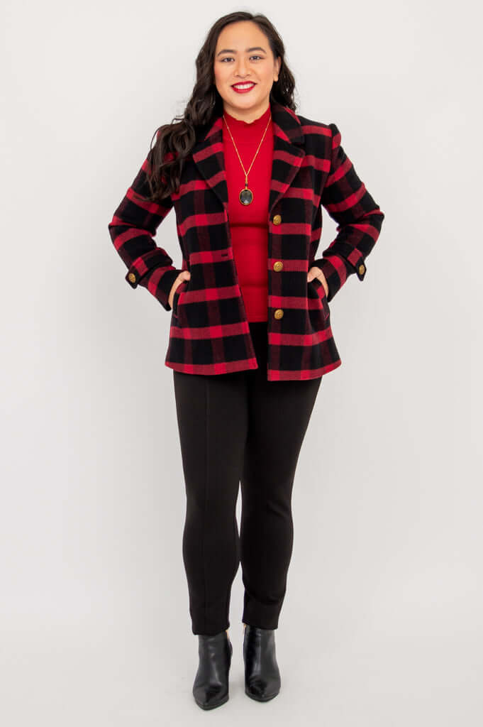 Woman posing with hands in pockets in a plaid wool blazer