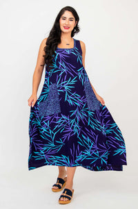 Woman spreading skirt of blue and purple botanical print dress, playful front view