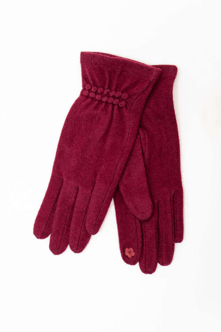 Pair of elegant plum wool gloves with textured cuff detailing on a white background