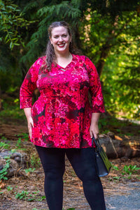 Plus-size model outdoors in pink floral Vana tunic with black leggings