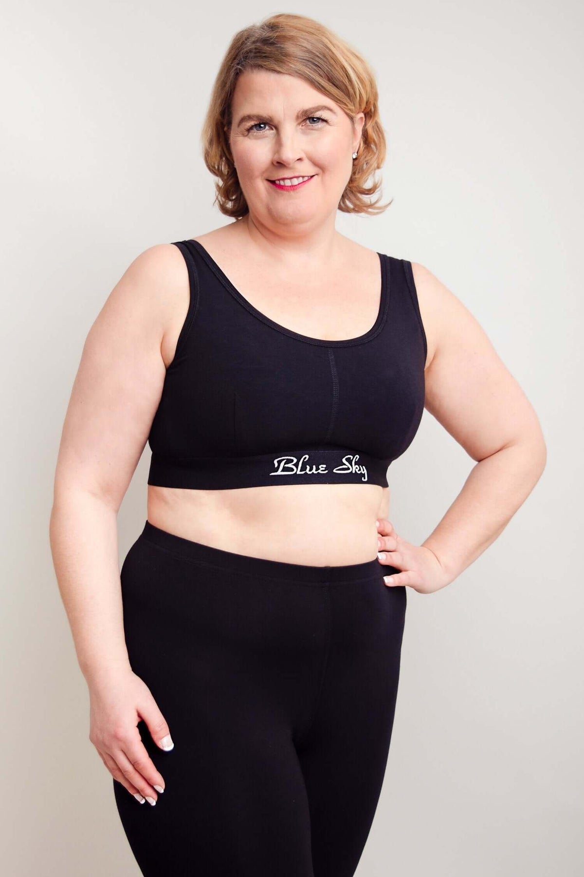 Angled front view of plus size woman in Blue Sky black comfort bra and pants