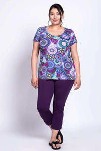 Plus size woman in purple mandala bamboo top paired with purple pants and sandals