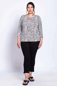 Plus size woman wearing a fitted black and white rose print tee and black pants