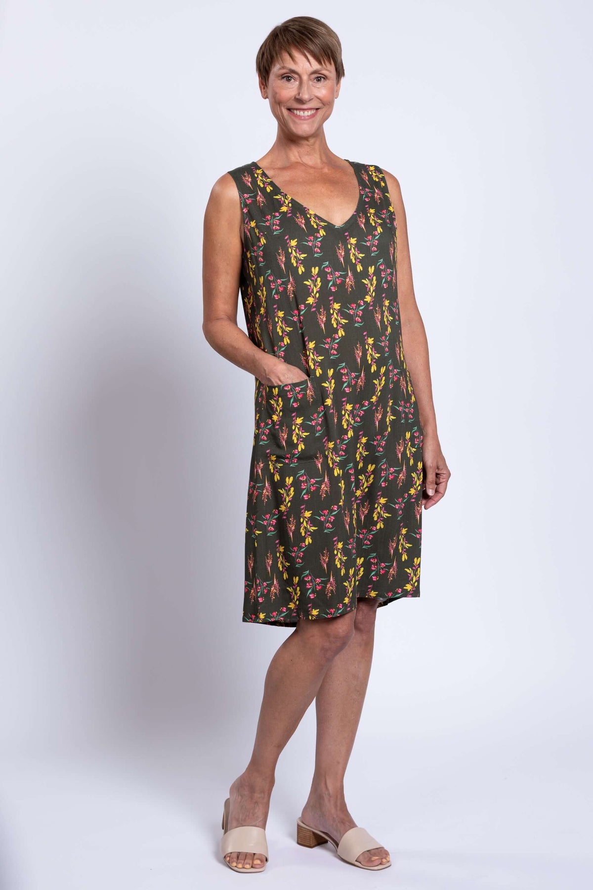 Woman showing front pocket details of sleeveless Felicia dress