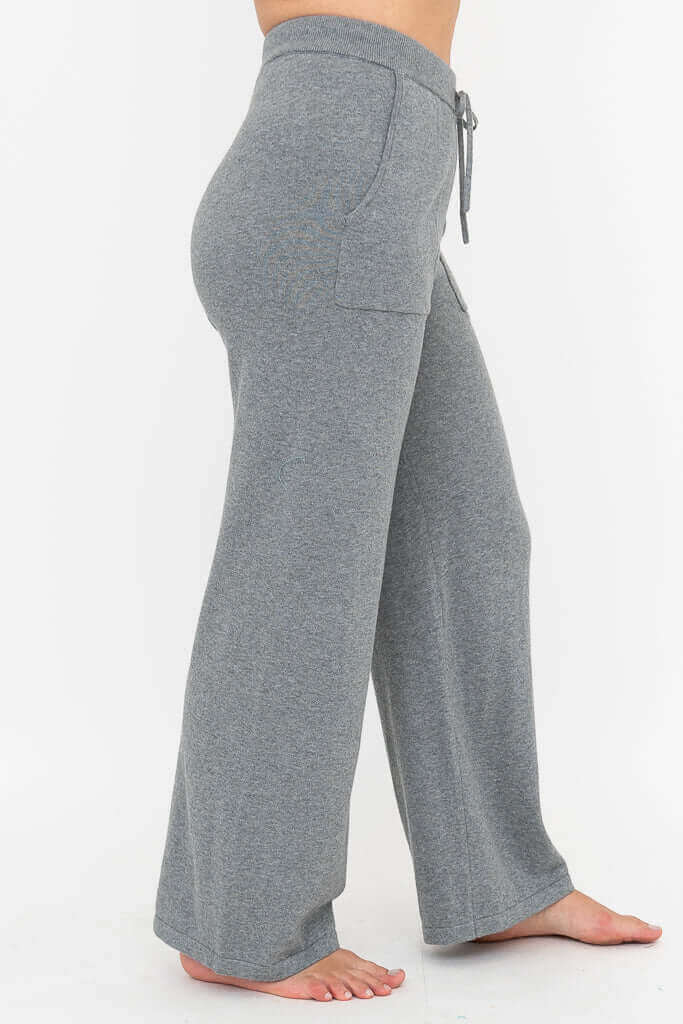 Side profile of grey cotton knit wide leg pants with front pockets and ribbed waistband