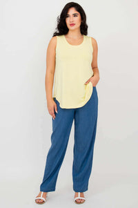Model posing with hand in pocket, wearing lemon bamboo tank and blue pants