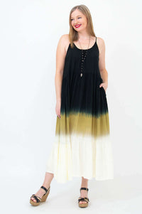 Woman posing with hand in pocket wearing a sleeveless black to golden ombre maxi dress