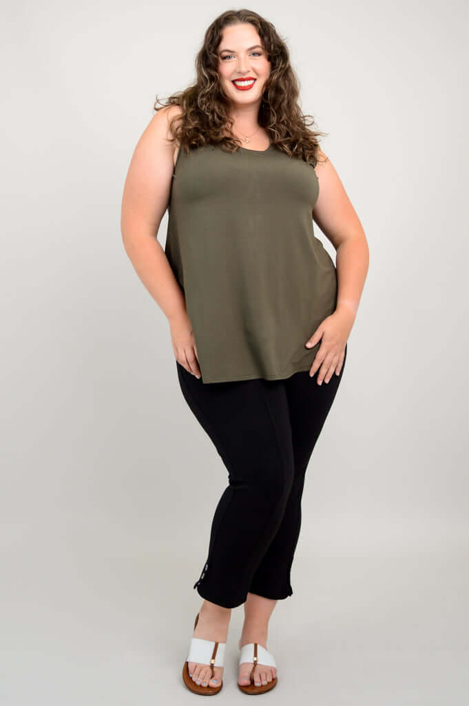Plus-size model posing in olive green sleeveless tank and black pants