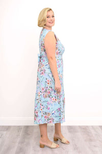 Profile view of a woman in a sleeveless blue floral midi dress with tie-back detail