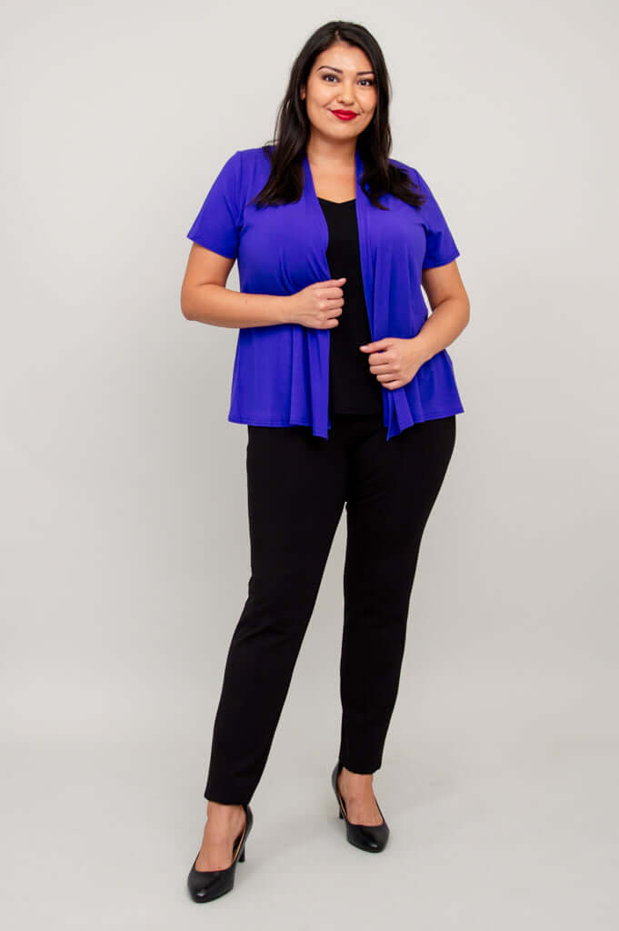 Model with hand on jacket edge, purple short sleeve jacket and black pants