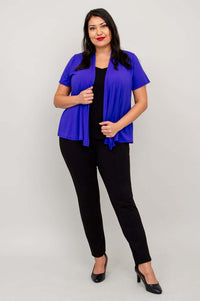 Model in a purple open-front short sleeve jacket and black pants, hand holding jacket edge