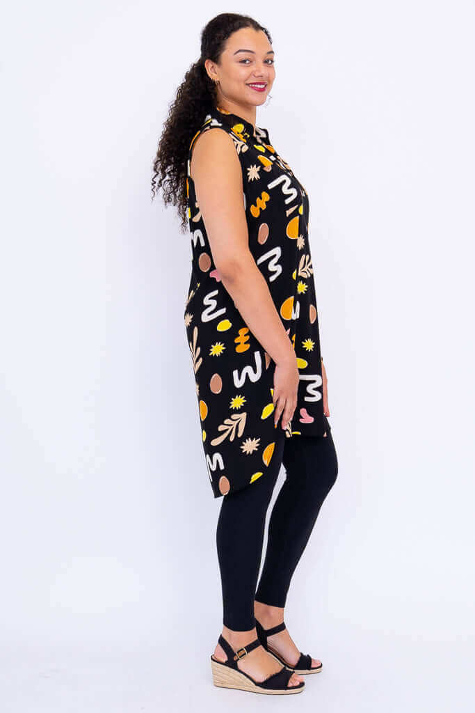 Side profile of model in Queenie sleeveless tunic and wedge sandals